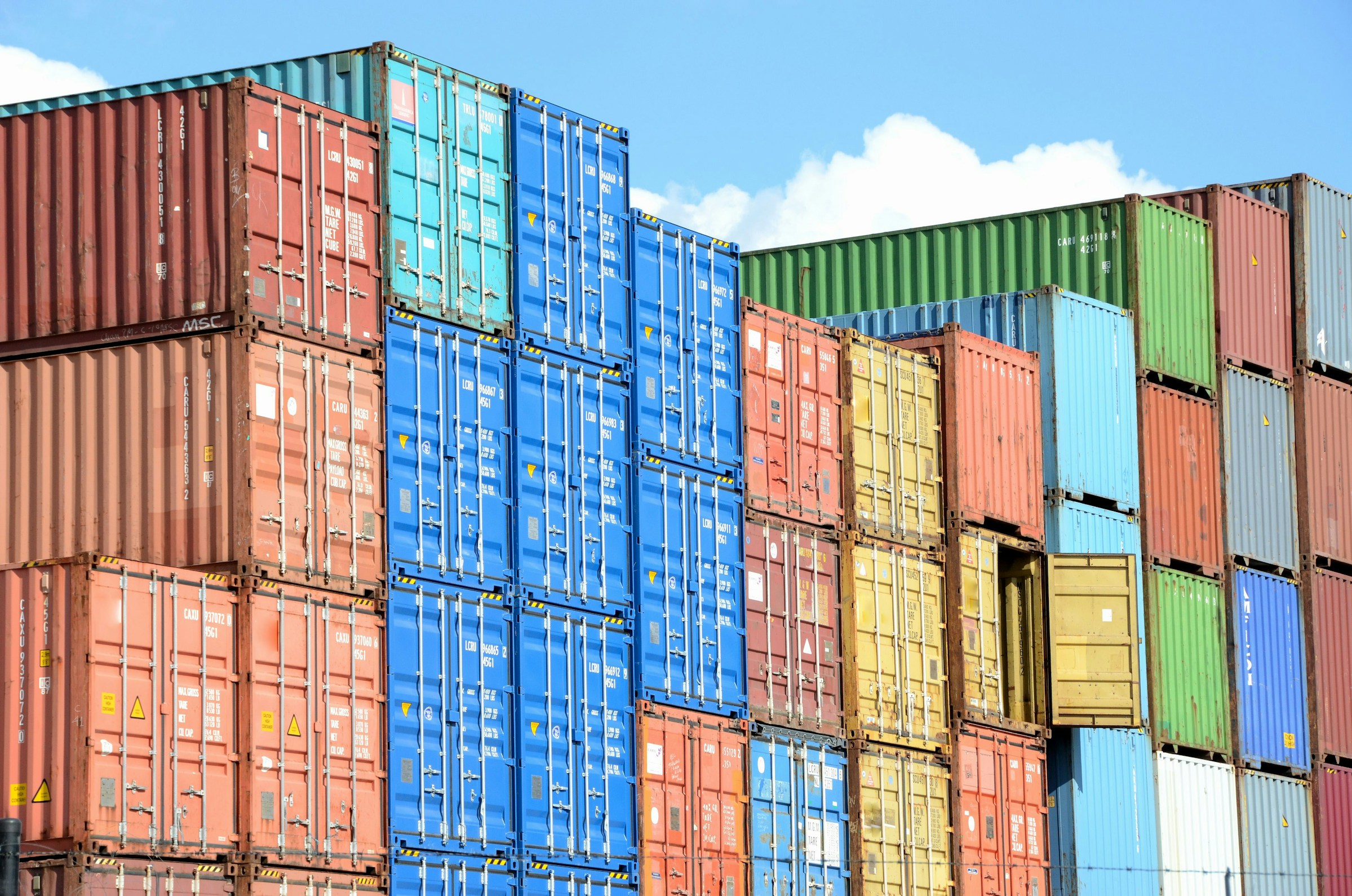 Stacked shipping containers against a blue sky