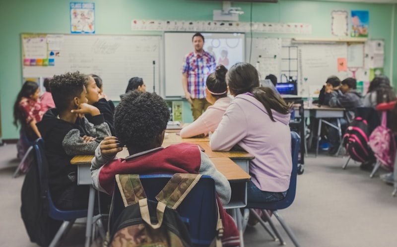 Students in a rural school classroom listening to a teacher